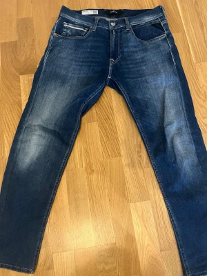 Mörkblå Replay Grover jeans - Snygga mörkblå jeans från Replay, modell Grover. Klassisk femficksdesign med lätt slitna detaljer och raka ben. Jeansen har en autentisk tvättad look och är perfekta för en avslappnad stil. Materialet är denim med skön känsla.