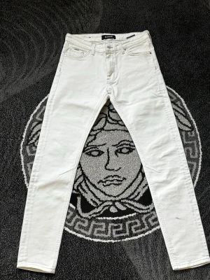 Vita slim fit jeans från Kani - Snygga vita slim fit jeans från Kani med klassisk femficksdesign och raka ben. Jeansen har en modern passform och är tillverkade i ett mjukt bomullsmaterial som ger en skön känsla. Perfekta för dig som vill ha en clean och stilren look.