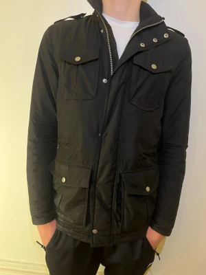 J Lindberg field jacket. - Säljer denna feta J.Lindberg field jacka, perfekt nu inför vintern då den är varmare än vad den ser ut. Jag på bilden är 184cm och den sitter fint på mig så är du runt 180 är det något för dig. Hör av dig vid frågor och funderingar!