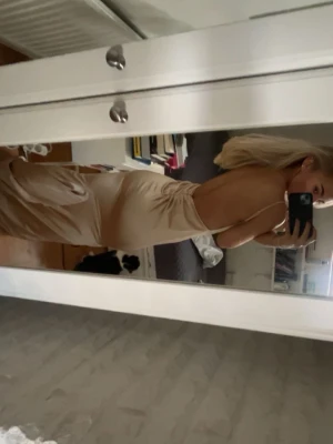 Champagnefärgad långklänning i satin - Säljer en elegant långklänning i champagnefärgad satin med djup v-ringning och öppen rygg. Nypris 2250 från ZARA. Pris kan diskuteras.