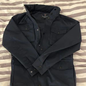 Bondelid field jacket  - Säljer nu denna extremt snygga Bondelid Gerrard field jacka i mörkblåa färg, pga att jag inte använt den så mycket. Jackan är i helt perfekt skick, köpte den cirka 2 månader sen på MQ för 1800kr. Hör av er vid funderingar eller frågor! 