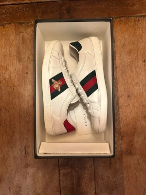 Gucci Ace Bee I 42 I Mycket bra skick! - Äkta Gucci Ace Bee i storlek 42. Skicket är mycket bra utan några några tydliga defekter, dock en liten reda på ena tån. Låda och äkthetsbevis följer med. Hör av dig vid frågor eller prisförslag!