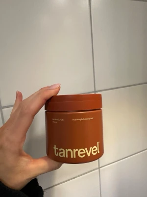 Tanrevel Exfoliating Pads - Hydrating Exfoliating Pads från Tanrevel i en brun rund plastburk. pads som används för att exfoliera och återfukta huden. Perfekt för dig som vill förbereda huden inför brun utan sol eller bara fräscha upp ansiktet. Nu 299kr