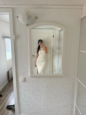 Vit långklänning med slits - Snygg vit långklänning med smala axelband och en slits på sidan. 