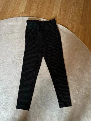 Tygbyxor från Only - Svarta tygbyxor med vita ränder från Only. Storlek XS, ankellängd! 