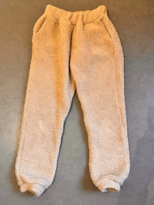 Mjukisbyxor Teddy - Mjukisbyxor i teddymaterial. Inte mycket använda. Dock lite noppriga inuti som syns på bild. Står storlek XS i dem men de är ganska långa och har passat mig som annars har S.