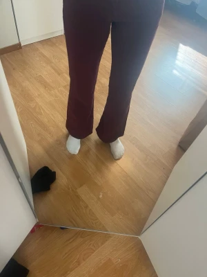 Vinröda bootcut jeans - Snygga vinröda jeans med bootcut passform och klassiska fem fickor. Jeansen har silverfärgade knappar.