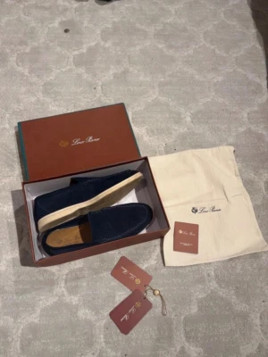 Blå mocka loafers från Loro Piana - Snygga loafers från Loro Piana i mörk sopblå mocka med klassisk slip-on design och ljus sula. Skorna har märkets logga på innersulan och kommer med originalkartong, dustbag och tags. Perfekta för en stilren och avslappnad look. Storlek 44 men funkar för 43