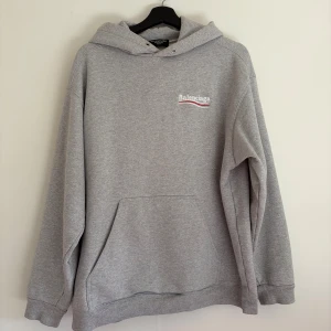 Balenciaga Political Campaign hoodie - Säljer nu min klassiska Balenciaga-hoodie. En tidlös streetwear-favorit som aldrig går ur tiden.  Detaljer: • Märke: Balenciaga • Modell: Political Campaign Logo Hoodie • Färg: Ljusgrå melerad (Heather Grey) • Skick: Mycket gott skick, väl omhändertagen. Inga fläckar eller hål.  Bara att höra av sig om man undrar något!