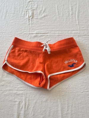 Orange shorts från Hollister med snörning - Orangea lågmidjade mjukisshorts ifrån Hollister i storlek M! 