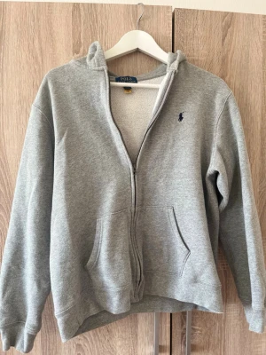 Grå kofta från Polo Ralph Lauren - Säljer en äkta grå kofta från Polo Ralph Lauren. Passar storlek xs.