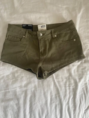 Olivgröna lågmidjade shorts från H&M - Säljer ett par olivgröna shorts från H&M med super låg midja!💕 Har aldrig använt och prislappen finns med. Passar för de som har strlk 34 och 36