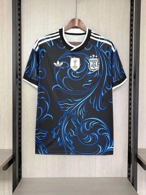 Argentina Adidas svart fotbollströja - Snygg svart fotbollströja från Adidas med Argentina AFA-emblem och FIFA-märke på bröstet. Tröjan har ett unikt blått och ljusblått mönster över hela ytan, vita detaljer vid krage och axlar samt korta ärmar. Perfekt för dig som vill sticka ut på planen.