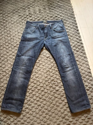 Raka jeans från Lee - Säljer ett par unika blå jeans från Lee med raka ben. Inte mycket använda. Hör av dig vid funderingar!