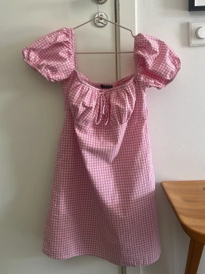 Rosa rutig kortklänning med puffärm - Supersöt rosa och vit rutig klänning från Zara . Bra skick!
