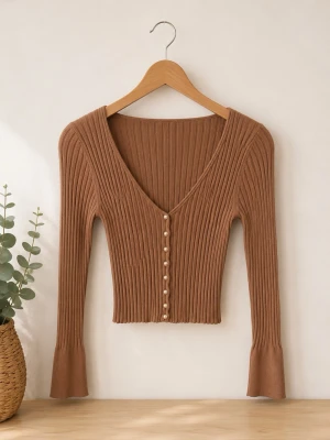 Brun ribbad kofta med pärlknappar - Snygg brun ribbstickad kofta med djup v-ringning och pärlknappar framtill. Långa ärmar med lätt utsvängda ärmslut. Tillverkad i viskos, polyester och nylon för en mjuk och stretchig känsla.
