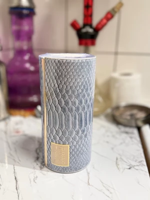 Parfym mussamam lataffa - Lyxig parfym från lataffa i en snygg cylinderformad förpackning med grått ormmönster och gulddetaljer. Perfekt för dig som gillar exklusiv design och vill ha något unikt på parfymhyllan.