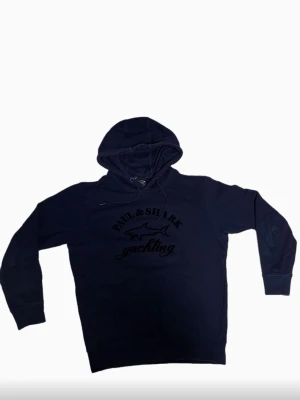 Mörkblå hoodie från Paul & Shark - Säljer en mörkblå Paul & Shark hoodie i väldigt fint skick. En perfekt kombination av komfort och stil, stilren och enkel att matcha med nästan allt. Ett plagg som funkar lika bra till vardags som till en mer välklädd look.  ✔ Mjuk och skön kvalitet ✔ Klassisk mörkblå färg – lätt att matcha ✔ Väldigt fint skick  Hör gärna av dig vid frågor. Skickas snabbt 📦