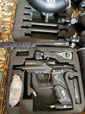 Paintballpaket med markör och tillbehör - Säljer ett komplett paintballpaket med svart Valken paintballmarkör, flera svarta lufttuber, loader, pipor, bälteshållare och rengöringsborste. Allt ligger i en praktisk väska och passar dig som vill komma igång med paintball direkt.