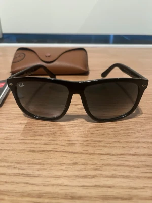 Svarta Ray-Ban Boyfriend Wayfarer 4147 - Klassiska svarta Ray-Ban Wayfarer solglasögon med bred båge och mörka glas. Snygg och tidlös design som passar till allt. Kommer med original brunt fodral och Ray-Ban logga på linsen.