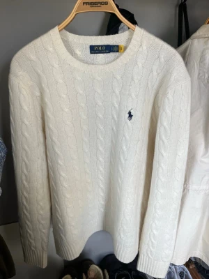 Kabelstickad kaschmirtröja Ralph Lauren - Eftertraktad kabelstickad tröja i kaschmir från Polo Ralph Lauren. Endast använd ett fåtal gånger, säljes för att jag tröttnat på den. Tröjan är i storlek L, men ganska liten i passformen så den sitter som en M. Nypris ligger runt 2700kr. Skriv gärna vid frågor. 