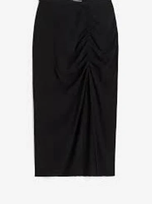 Svart långkjol med slits - Snygg svart långkjol med rynkade detaljer framtill som ger en cool och trendig look. Kjolen har en rak passform och är perfekt att styla med både sneakers och boots. Materialet känns mjukt och följsamt mot kroppen.