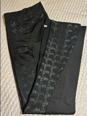 Better Bodies Flare Tights 🖤 Strl S / 36 - Unika Better Bodies träningstights i eftertraktad flare-modell med hög midja! Mycket bra skick. Stilrena svarta paneler längs sidorna med ett glansigt, geometriskt logomönster. Kraftigt, stretchigt material som håller formen och är helt squat proof (ej genomskinliga)! 🍑✨Mått (platt):Midja: ca 32 cmInnelängd: ca 81 cmTotal längd: ca 102 cmBenvidd nertill: ca 20 cmPerfekta till gymmet, yogan eller vardags!