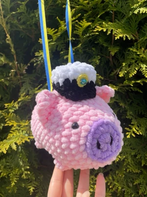 Virkad studentgris som studenthänge!🎁🥳🎊 - Söt handvirkad gris i mjuk rosa plysch med lila tryne och svarta ögon. Grisen har en virkad studentmössa med blå pärla och hängs med blågula band. Perfekt som studenthänge om man vill ge något personligt och unikt! 
