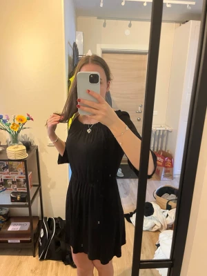 Svart off shoulder klänning - Snygg svart klänning med off shoulder-modell och resår i midjan. Klänningen har trekvartsärmar och en lätt utställd kjol. Perfekt för dig som gillar en enkel men trendig stil. Materialet känns mjukt och följsamt mot kroppen.