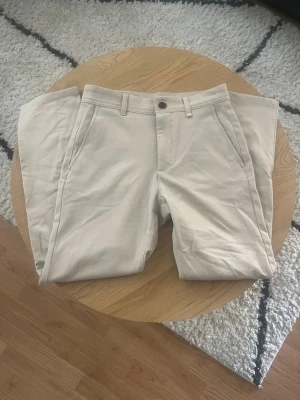 Beige chinos Zara - Tjena👋 Säljer dessa snygga beige chinos med raka ben och klassisk passform🤩 Byxorna har sidfickor fram, två bakfickor med knapp och hällor för bälte😮‍💨 Perfekta för en clean och stilren look🧼 Tillverkade i mjukt bomullstyg🧶 Perfekta för sommaren!☀️ Storlek 36 (S)📐 Meddela gärna vid frågor eller fler bilder!📩