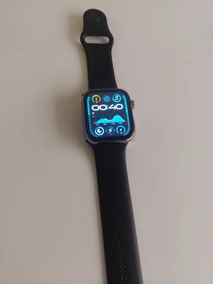 Svart smartklocka med silikonarmband - Beskrivning ​Skick: Helt ny. Kommer i originalförpackning med alla tillbehör. ​Vad som ingår: ​Smartklocka: Stilren, mörk metallram med en skarp och rektangulär touchskärm. ​Armband: Klarrytt sportband i silikon (bekvämt, tåligt och justerbart). ​Laddare: Tillhörande magnetisk laddningsdocka med USB-A-kabel. ​Dokumentation: Originalmanual / användarhandbok. ​Nyckelfunktioner & Inbyggda appar: ​Hälsa- & Träningsmätning: Pulsmätare, s