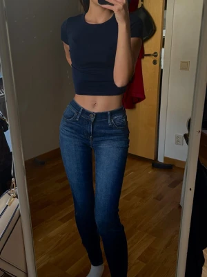 Mörkblå levi’s skinny jeans - Säljer ett par mörkblå skinny jeans med klassisk femficksdesign. Jeansen har smal passform och stretchigt material som sitter tajt längs benen. 
