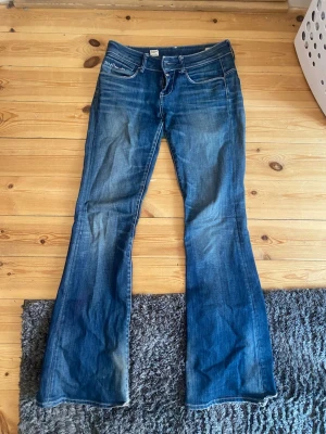 Blå bootcut jeans från G-Star RAW - Snygga blå bootcut jeans från G-Star RAW med klassisk femficksdesign och broderad text på fickan. Jeansen har en lätt tvättad look och markerade sömmar. Jag är 160 cm lång! 