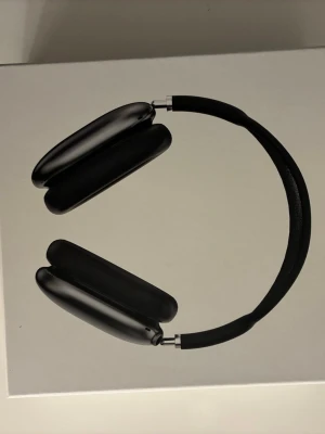 Apple AirPods Max Svart - Snygga och moderna over-ear hörlurar från Apple i svart färg. AirPods Max har en stilren design med aluminiumkåpor, meshbygel och mjuka öronkuddar för extra komfort. Perfekta för musik, gaming eller videos med grym ljudkvalitet och aktiv brusreducering.