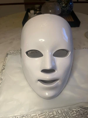 LED-ljusmask för ansiktsbehandling - LED-ljusmask för ansiktet med flera små lampor inbyggda i masken. Masken har öppningar för ögon, näsa och mun. Perfekt för dig som vill boosta din hudvårdsrutin med ljusbehandling hemma. Ny!