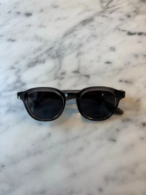 S&T 001 Greige - Stig fram med stil och självförtroende i våra solglasögon 001. Med en elegant och modern design är dessa solglasögon det perfekta accessoaret för att komplettera din sommarlook. Tillverkade med högkvalitativa material och med omsorgsfullt utformade detaljer, erbjuder de inte bara en trendig estetik utan också överlägsen skydd mot solens strålar. Med sina mångsidiga och universellt smickrande form passar de alla ansiktsformer och ger en sofistikerad touch till varje outfit. 