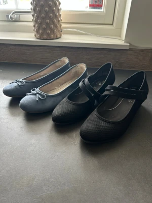 Blå svarta ballerinaskor från Jana - Snygga blå ballerinaskor från Jana med rund tå och dekorativ rosett framtill. Skorna är i mockaimitation och har en klassisk, stilren design som passar till många outfits. Aldrig använda! Svarta mockaskor använda en gång på bal,nyskick! sköna o gå i.  blå skor 300:- svarta 450:-