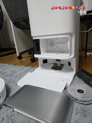 Dreame robotdammsugare med station D10 ultra gen 3 .....25 000 pa - Robotdammsugare från Dreame med tillhörande ladd- och rengöringsstation. Vit och svart design med runda grå mopphuvuden undertill. Stationen har öppningsbar front och plats för tillbehör. Perfekt för smart städning av hemmet.