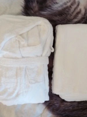 Vit fluffig morgonrock i frotté - Supermjuk mysig vit morgonrock och badlakan 100x145 i frotté, perfekt att svepa in sig i efter duschen eller när du vill chilla hemma. Klassisk modell med knytskärp i midjan och stora fickor framtill. Enkel och stilren design som passar alla.