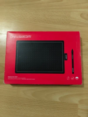 Wacom One ritplatta med penna - Säljer en Wacom One ritplatta i svart med tillhörande penna och USB-kabel. Perfekt för digitalt skapande, anteckningar eller redigering. Plattan har en slimmad, rektangulär form och är tillverkad i plast. Allt levereras i originalförpackning.
