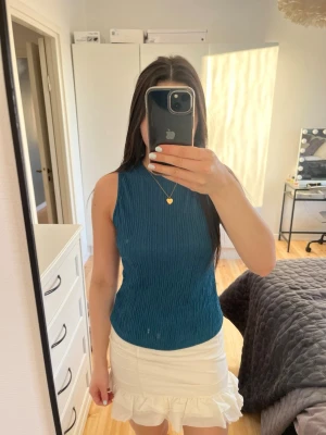 Blå ribbad ärmlös topp - Säljer en blå ribbad topp med hög hals och ärmlös design. Om ni är intresserade i kjolen finns de i ett annat inlägg!😁Tyget har en snygg struktur och toppen är perfekt att styla med kjol eller jeans. Enkel men trendig modell som passar till många olika looks.🤩