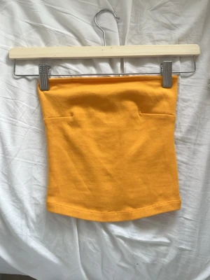 Gul ribbad tubtopp - Snygg gul ribbad tubtopp i stretchigt material. Toppen är axelbandslös och har en enkel, clean design som passar perfekt till jeans eller kjol. Från GinaTricot i XXS men stretchig. Pris diskuteras gärna och skicka om ni har frågor! På insidan av toppen finns en gummikant så att den inte åker ned. 