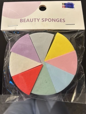 Färgglada sminksvampar i tårtbitsform - Säljer ett set med åtta sminksvampar i olika färger och tårtbitsform. Perfekta för att applicera foundation, concealer eller puder. Svamparna är mjuka och gjorda av skumgummi för en jämn finish. Färgerna är gul, rosa, blå, grön, röd, vit och lila.