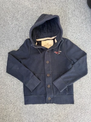 Hollister cardigan | L - Vintage hollister cardigan | riktigt schysst | Hål är gjorda av tidigare ägare för vintage/archive look (se sista bild) | Mycket bra skick | Marinblå | hör av er vid frågor eller prisförslag!