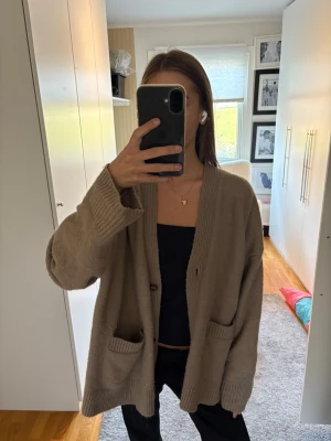 Beige oversized kofta med fickor - Mysig oversized kofta i beige med två stora fickor framtill 