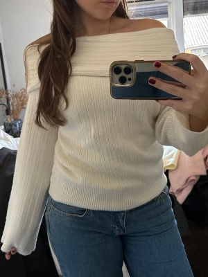 Off shoulder vit stickad tröja - Trendig off shoulder stickad tröja i vit färg med bred ribbstickning. Tröjan har långa ärmar och en bred, vikt kant upptill. Storlek S från Nelly💕