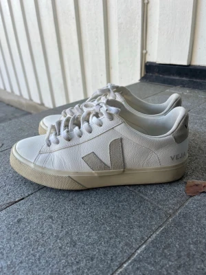 Vita Veja sneakers - Snygga vita sneakers från Veja i mjukt läder med beige sula och klassisk V-logga på sidan. Sparsamt använda!! 😊🫶🏼