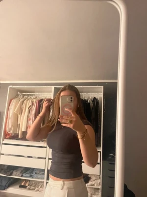 Svart tight ärmlös topp - Säljer en svart, tight och ärmlös topp med rund hals. Toppen har en enkel och stilren design som passar perfekt till både jeans och kjol. Materialet känns mjukt och stretchigt för en bekväm passform.