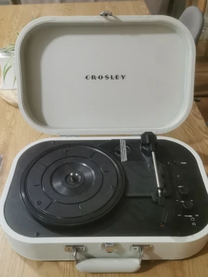 Crosley portabel vinylspelare utan sladd med vinylskiva  - Stilren portabel vinylspelare från Crosley i vit färg med svart insida. Spelaren har ett klassiskt resväskeformat med handtag och inbyggda reglage för volym och hastighet. Perfekt för att spela dina favoritvinylskivor hemma eller på språng. Men utan sladd då man kan beställa på nätet och travis scott vinylskiva astroworld