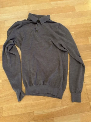  långärmad pikétröja - Säljer en  långärmad pikétröja med krage och tre knappar framtill. Storlek S, skick 9/10. Hör av er om ni har några funderingar!